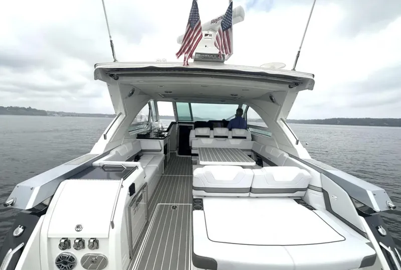 Slide: The Image of 2021 Formula 400 Super Sport Crossover yacht with spacious deck and seating on a calm lake. - 8