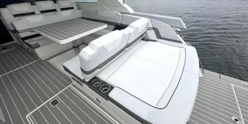 Slide: The Image of 2021 Formula 400 Super Sport Crossover boat interior with seating and table on water. - 9