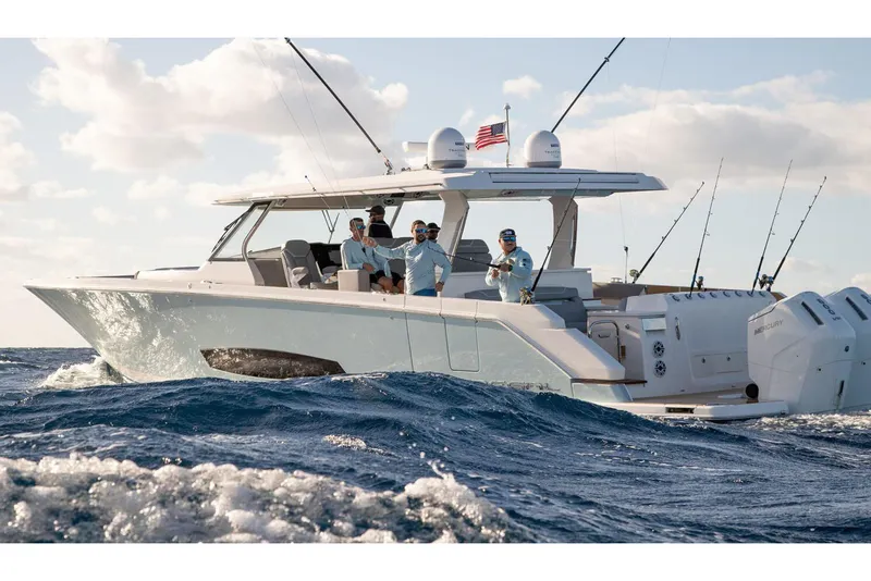 Slide: The Image of 2026 Regal 50 SAV boat cruising with passengers, fishing rods, and American flag. - 7