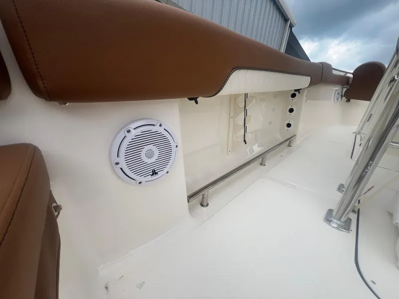 Slide: The Image of 2026 Pioneer 202 Islander boat interior with brown seating and built-in speaker system. - 10