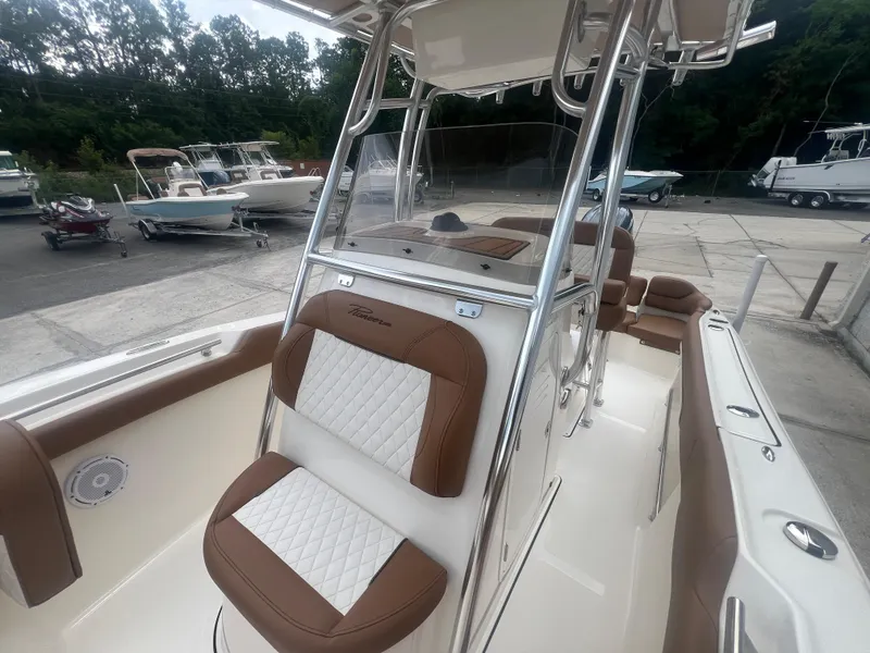 Slide: The Image of 2026 Pioneer 202 Islander boat with brown and white seating, docked outdoors. - 18