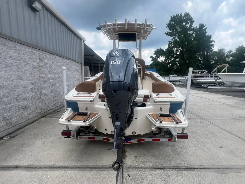 Slide: The Image of 2026 Pioneer 202 Islander boat with 150 HP engine, parked outdoors. - 3
