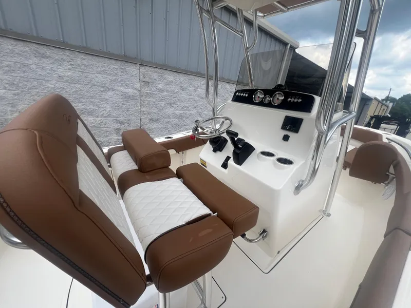Slide: The Image of 2026 Pioneer 202 Islander boat interior with brown and white seating, steering console, and gauges. - 6
