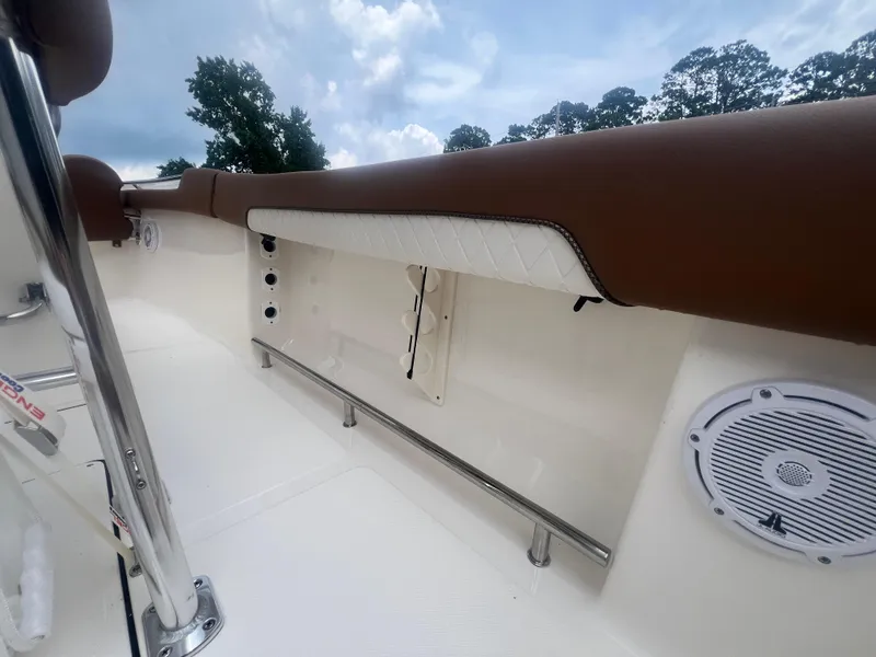 Slide: The Image of 2026 Pioneer 202 Islander boat interior with cushioned seating and speaker, under a cloudy sky. - 9