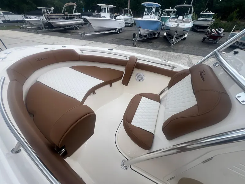 Slide: The Image of 2026 Pioneer 202 Islander boat interior with brown and white seating, docked among other boats. - 18