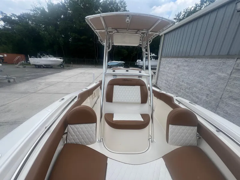Slide: The Image of 2026 Pioneer 202 Islander boat interior with brown and white seating, docked outdoors. - 20