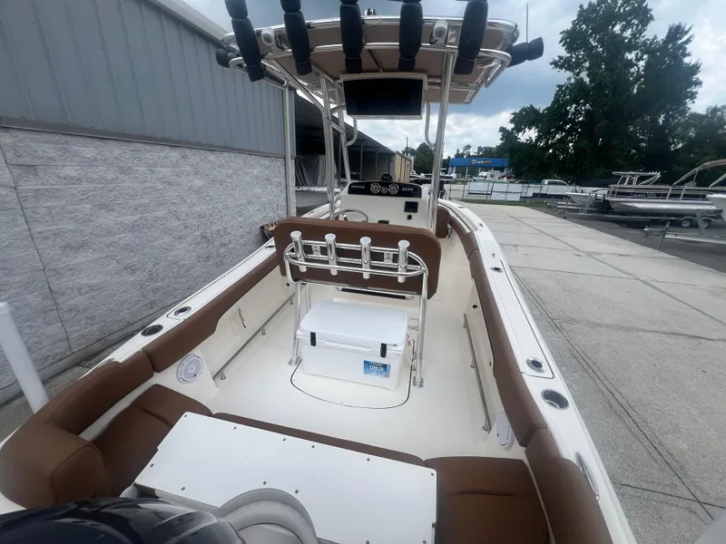 Slide: The Image of 2026 Pioneer 202 Islander boat with brown seating, rod holders, and a central console. - 5