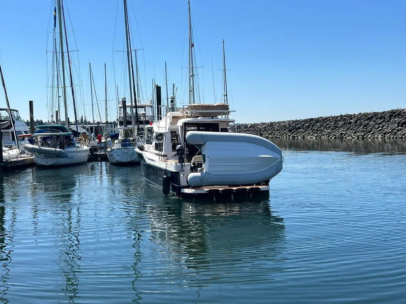 Slide: The Image of 2025 Ranger Tugs R-29 CB docked in a marina, surrounded by sailboats. - 18