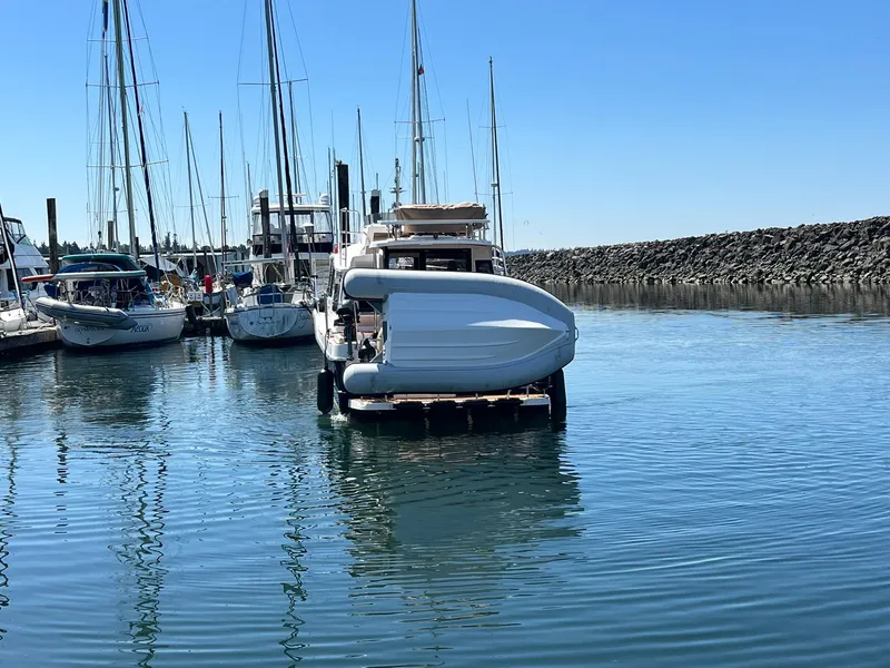 Slide: The Image of 2025 Ranger Tugs R-29 CB docked in a marina, surrounded by sailboats. - 19