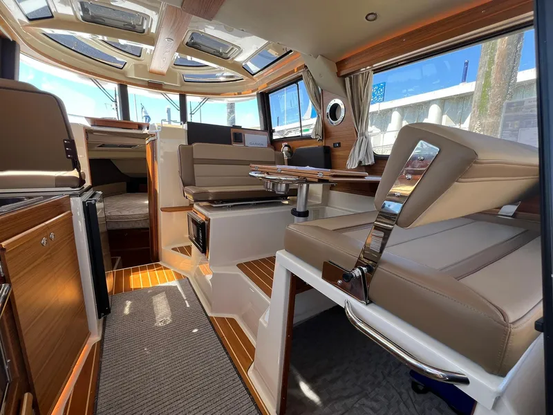 Slide: The Image of 2025 Ranger Tugs R-29 CB interior with modern seating and panoramic windows. - 24