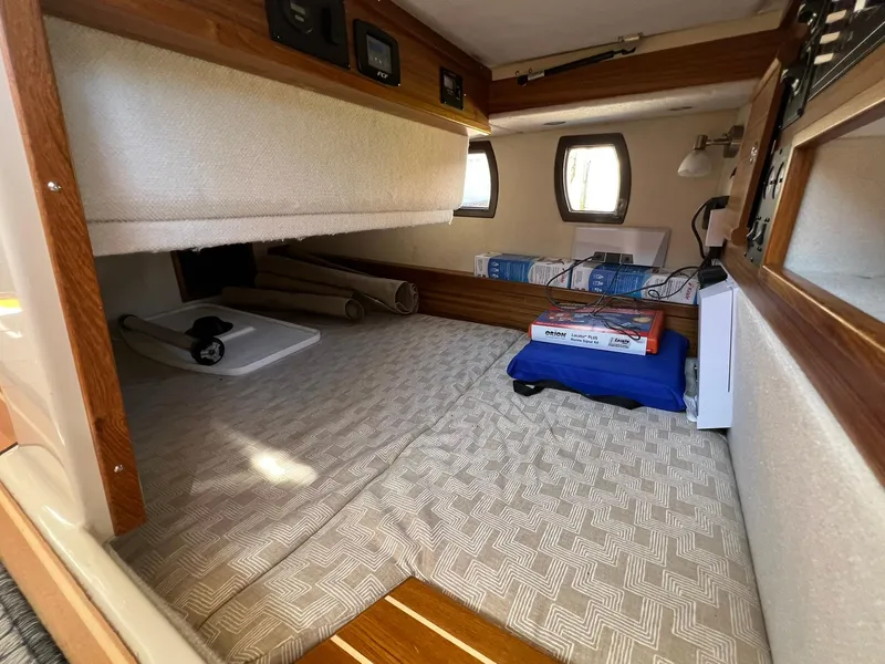 Slide: The Image of 2025 Ranger Tugs R-29 CB cabin interior with cozy bedding and storage space. - 25