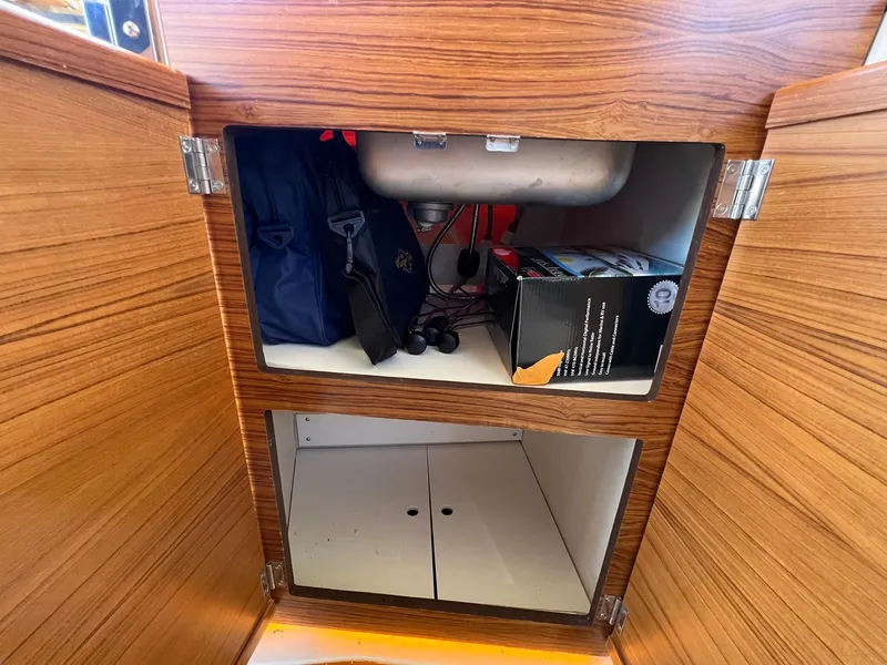 Slide: The Image of Cabinet storage inside 2025 Ranger Tugs R-29 CB boat, featuring wooden finish and organized compartments. - 26