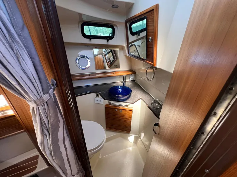 Slide: The Image of 2025 Ranger Tugs R-29 CB bathroom with modern fixtures and wooden accents. - 29