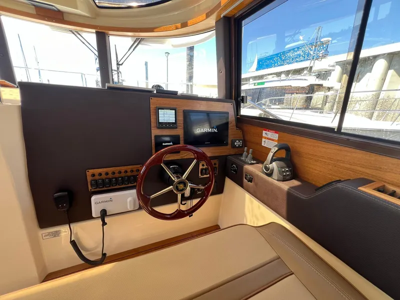 Slide: The Image of 2025 Ranger Tugs R-29 CB helm with Garmin navigation system and wooden steering wheel. - 33