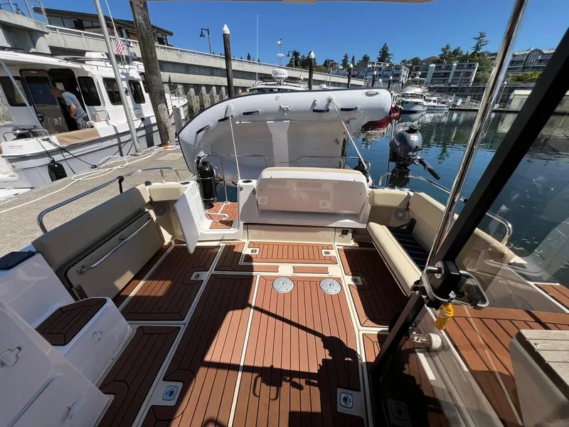 Slide: The Image of 2025 Ranger Tugs R-29 CB boat interior with teak flooring at a marina. - 35
