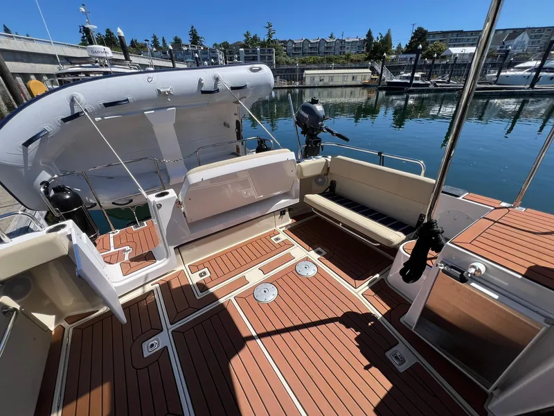 Slide: The Image of 2025 Ranger Tugs R-29 CB boat deck with seating and inflatable dinghy at marina. - 36