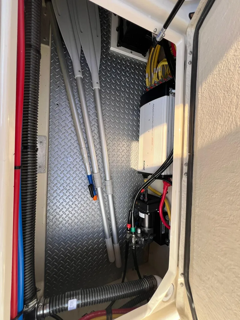 Slide: The Image of 2025 Ranger Tugs R-29 CB storage compartment with oars and electrical equipment. - 39