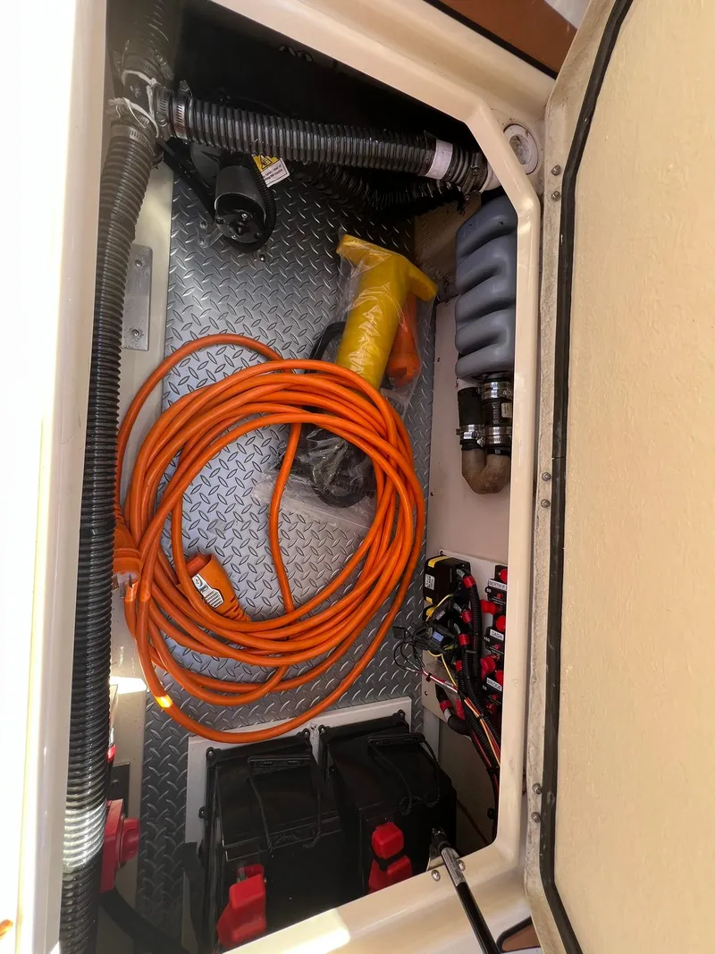 Slide: The Image of Storage compartment of 2025 Ranger Tugs R-29 CB with orange cable and equipment. - 40