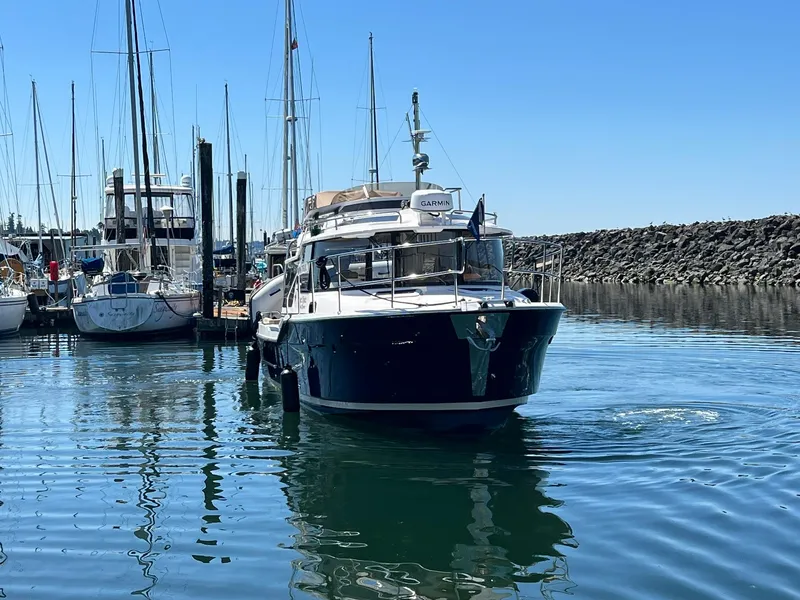 Slide: The Image of 2025 Ranger Tugs R-29 CB boat docked in a marina under clear blue skies. - 7