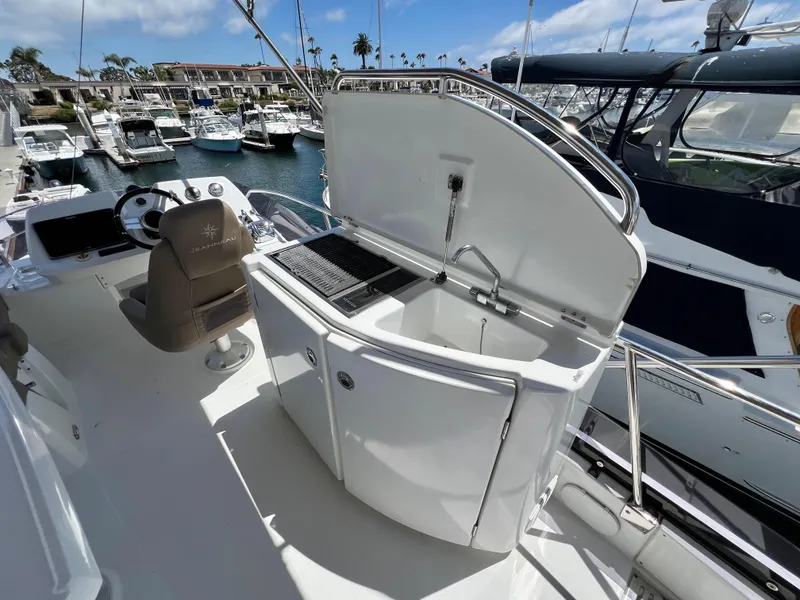 Slide: The Image of 2017 Jeanneau Velasco 43 yacht deck with helm, sink, and grill station. - 23