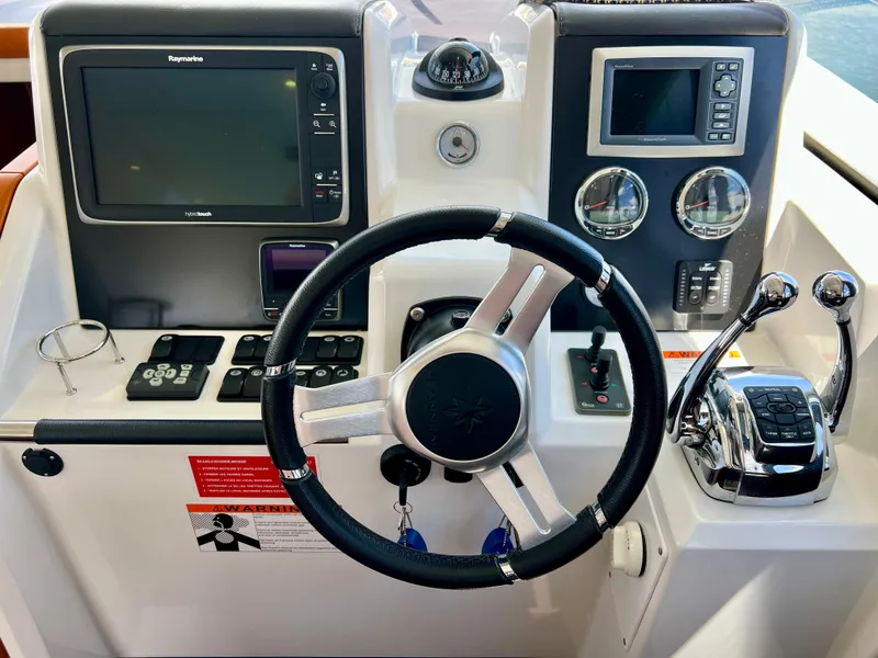 Slide: The Image of Control panel of a 2017 Jeanneau Velasco 43 boat with steering wheel and navigation instruments. - 26