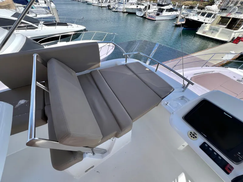 Slide: The Image of Flybridge seating on 2017 Jeanneau Velasco 43 yacht, overlooking marina with multiple boats. - 27