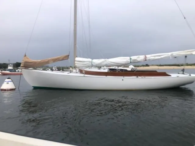Slide: The Image of Alerion 26 sailboat from 1999 moored on calm water under a cloudy sky. - 1