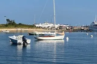 Slide: The Image of Sailboats anchored in a calm harbor, featuring a 1999 Alerion 26. - 10