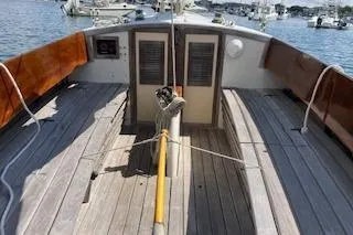 Slide: The Image of 1999 Alerion 26 sailboat deck with wooden finish, docked in a marina. - 12