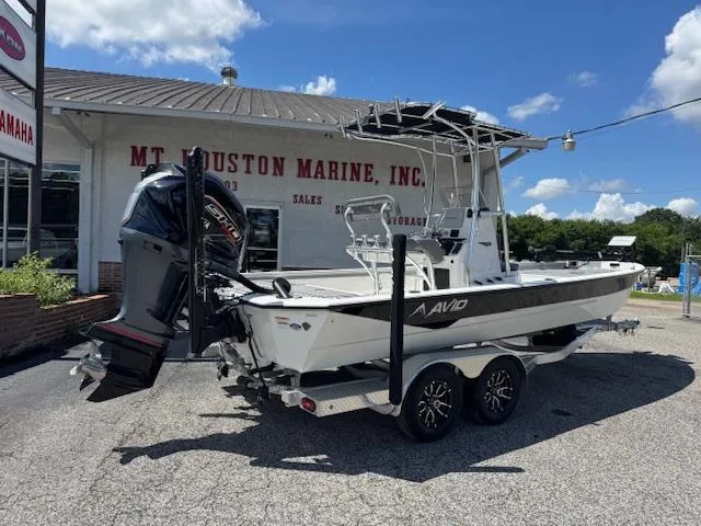 Slide: The Image of Avid 23 Mag 2025 boat on trailer at marine dealership under clear blue sky. - 5