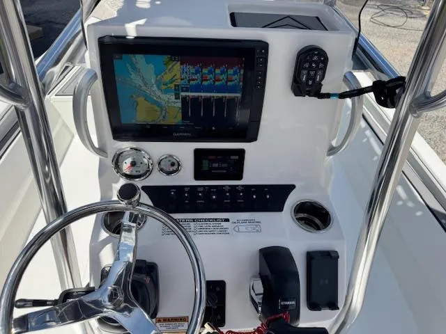 Slide: The Image of Boat dashboard with navigation screen, steering wheel, and controls on Avid 23 Mag, 2025 model. - 8
