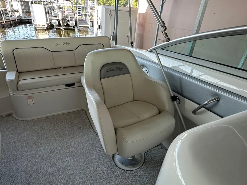 Slide: The Image of 2010 Sea Ray 240 Sundeck interior with beige seating and carpeted flooring. - 14