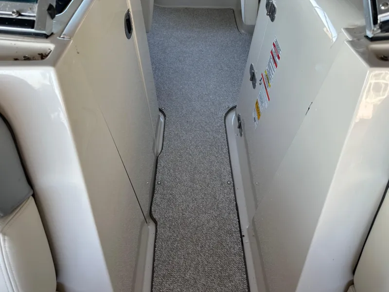 Slide: The Image of Interior view of a 2010 Sea Ray 240 Sundeck boat with carpeted flooring. - 19