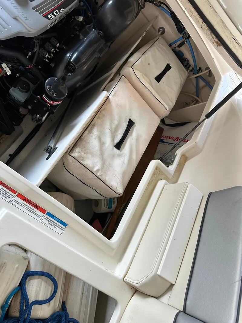Slide: The Image of Engine compartment of a 2010 Sea Ray 240 Sundeck boat with storage and cushions. - 22
