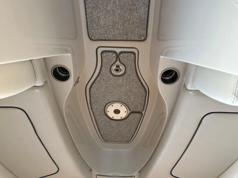 Slide: The Image of Interior view of 2010 Sea Ray 240 Sundeck boat, featuring carpeted flooring and seating. - 26