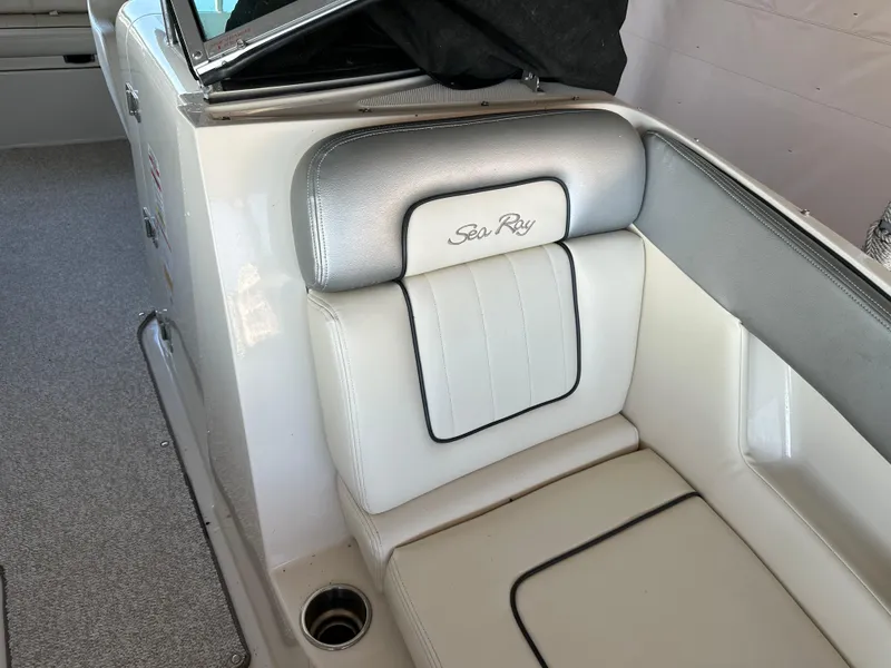 Slide: The Image of 2010 Sea Ray 240 Sundeck interior seating with logo, featuring white and gray upholstery. - 27