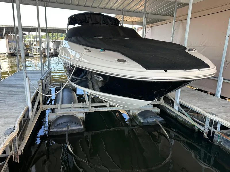 Slide: The Image of 2010 Sea Ray 240 Sundeck boat docked, covered, and elevated in a marina. - 28