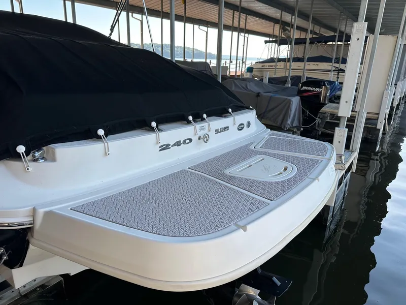 Slide: The Image of 2010 Sea Ray 240 Sundeck boat docked, featuring a spacious swim platform. - 3