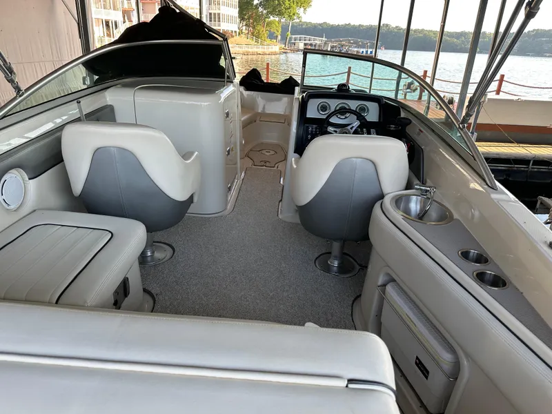 Slide: The Image of Interior of 2010 Sea Ray 240 Sundeck boat with seating and helm, docked by a lake. - 7