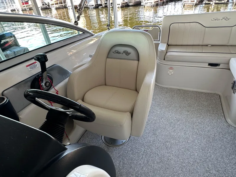 Slide: The Image of 2010 Sea Ray 240 Sundeck interior with helm seat and steering wheel. - 8
