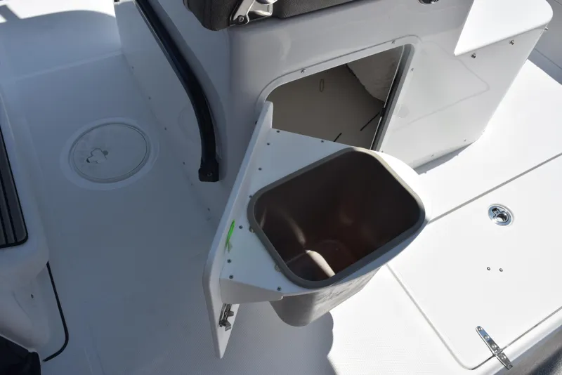 Slide: The Image of 2026 Sea Hunt Gamefish 30 boat interior with open storage compartment and trash bin. - 20