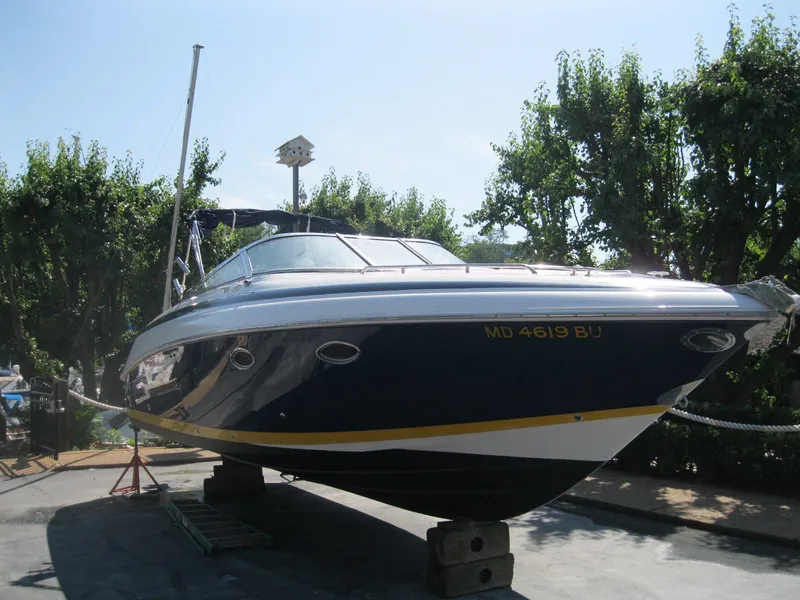 The Image of 2003 Cobalt 293 boat on dry dock, surrounded by trees, with registration number MD 4619 BU. - 0