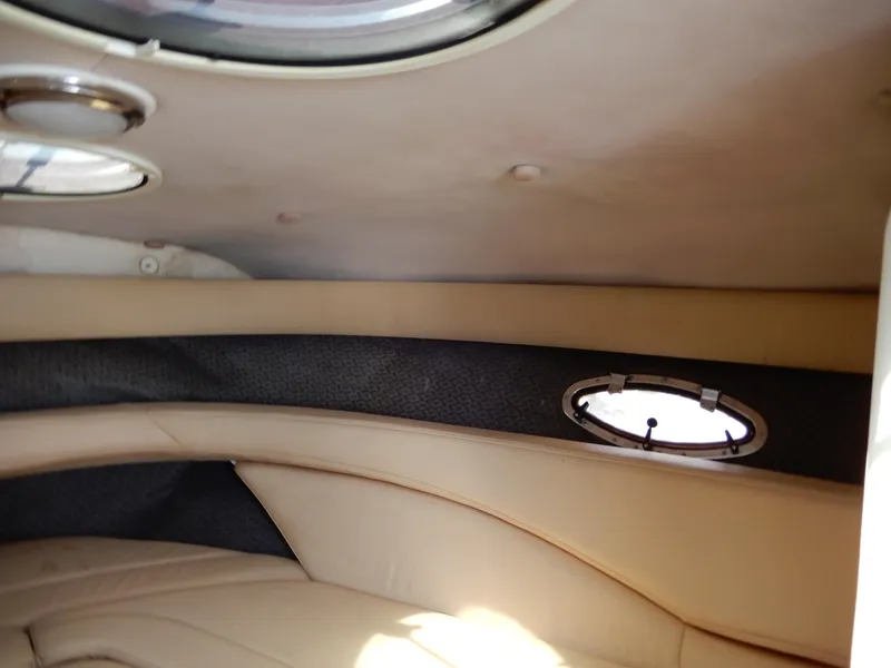 Slide: The Image of Interior cabin of a 2003 Cobalt 293 boat with beige upholstery and porthole windows. - 10