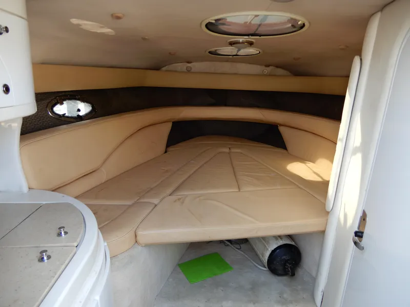 Slide: The Image of Interior cabin of a 2003 Cobalt 293 boat with beige seating and small porthole window. - 9