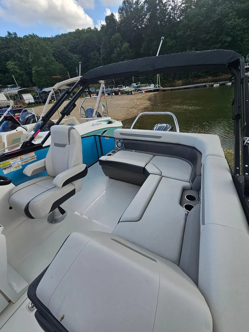 Slide: The Image of 2024 Hurricane FD 1960 RE3 OB boat interior with seating, docked by a lake. - 6