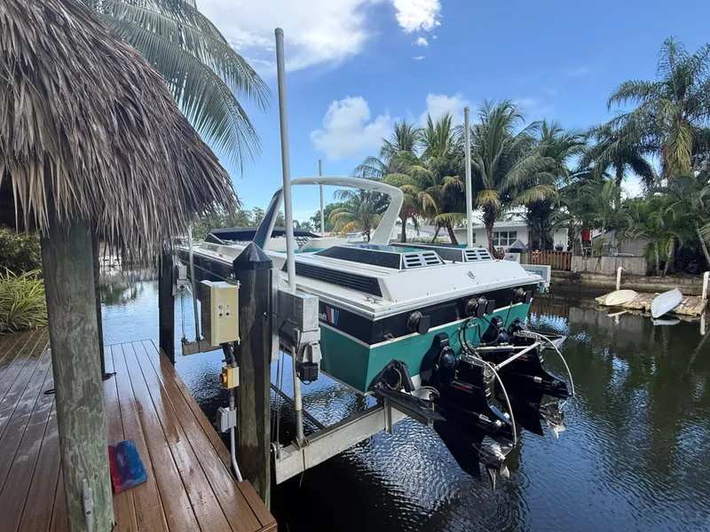 Slide: The Image of 1988 Wellcraft Scarab 38 KV boat docked near tropical palm trees and water. - 17