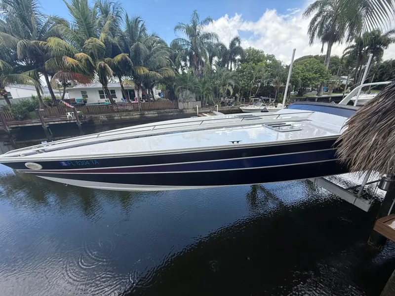 Slide: The Image of 1988 Wellcraft Scarab 38 KV boat docked on a calm waterway with palm trees. - 18