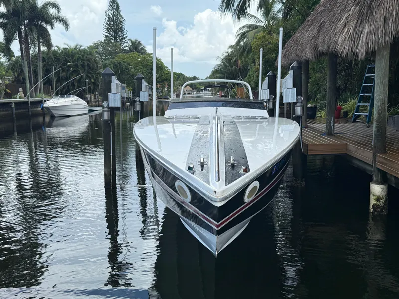 Slide: The Image of 1988 Wellcraft Scarab 38 KV docked in a tropical marina setting. - 2