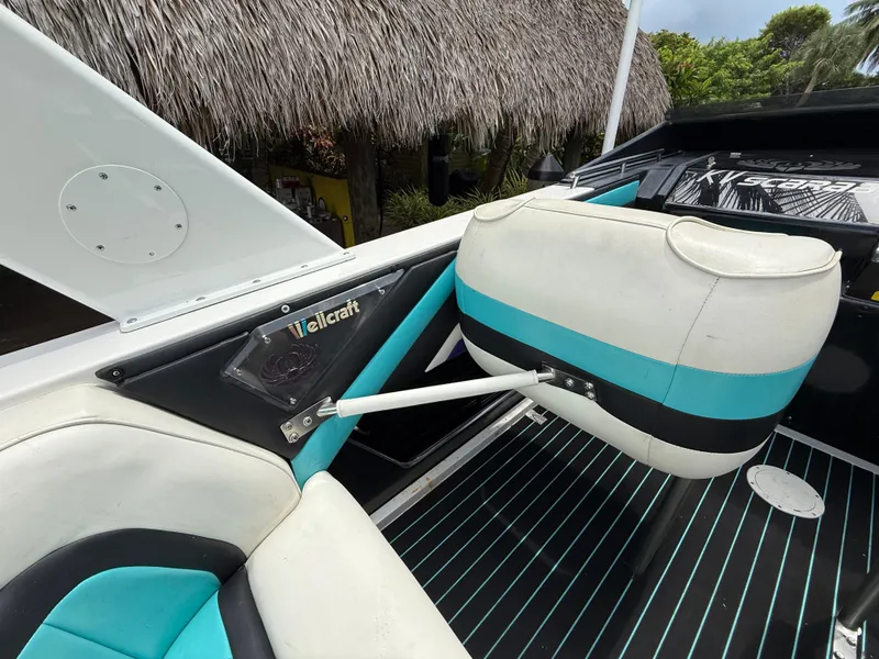 Slide: The Image of 1988 Wellcraft Scarab 38 KV boat interior with teal and white seating, tropical background. - 21