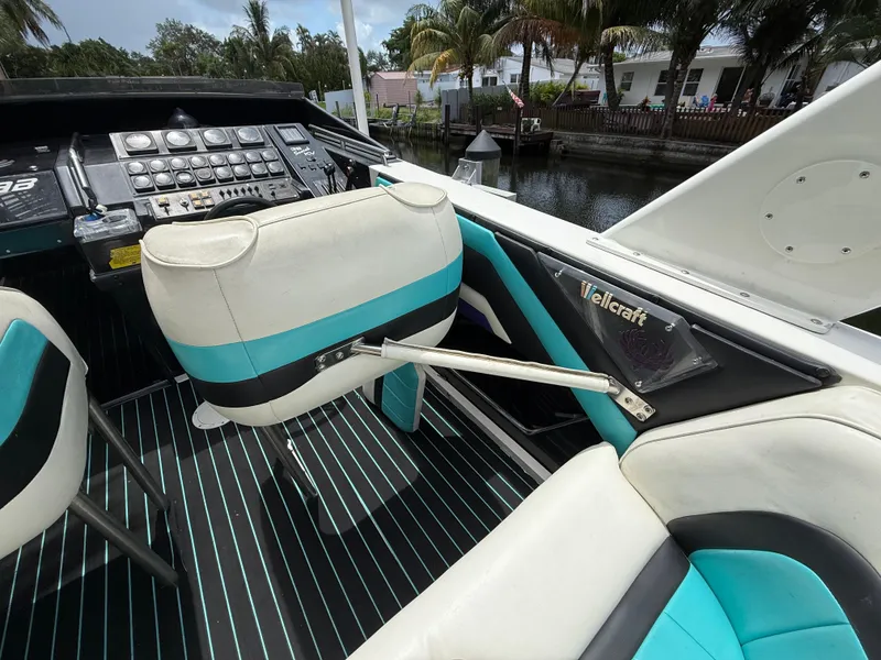 Slide: The Image of 1988 Wellcraft Scarab 38 KV boat interior with teal and white seating, control panel, and branding. - 22